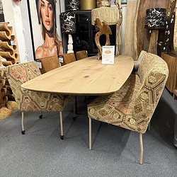 1. Mooi houten eettafel met stijlvolle stoffen eetkamerstoelen in een meubelwinkel, perfect voor moderne en landelijke interieurs.