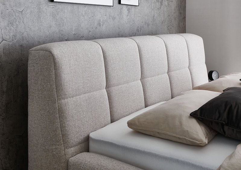 Zachte beige stoffen afgeronde bedrand met moderne design voor slaapkamermeubels.