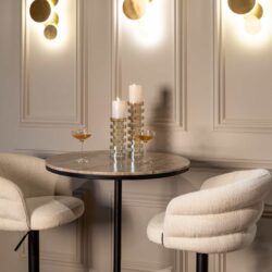 Wandlamp Collin in goudkleur in een woonkamer