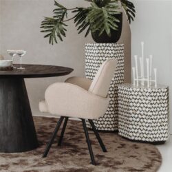 Zeer elegante en moderne eetkamerstoel met beige bekleding en zwarte houten poten, geplaatst in een stijlvolle interieursetting met decoratieve elementen en planten.