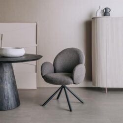 Zwart gestoffeerde bureaustoel met draaibasis in een modern interieur met minimalistische meubels.