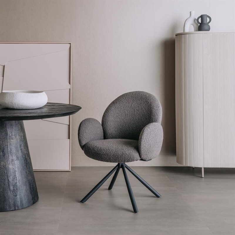 Zwart gestoffeerde bureaustoel met draaibasis in een modern interieur met minimalistische meubels.