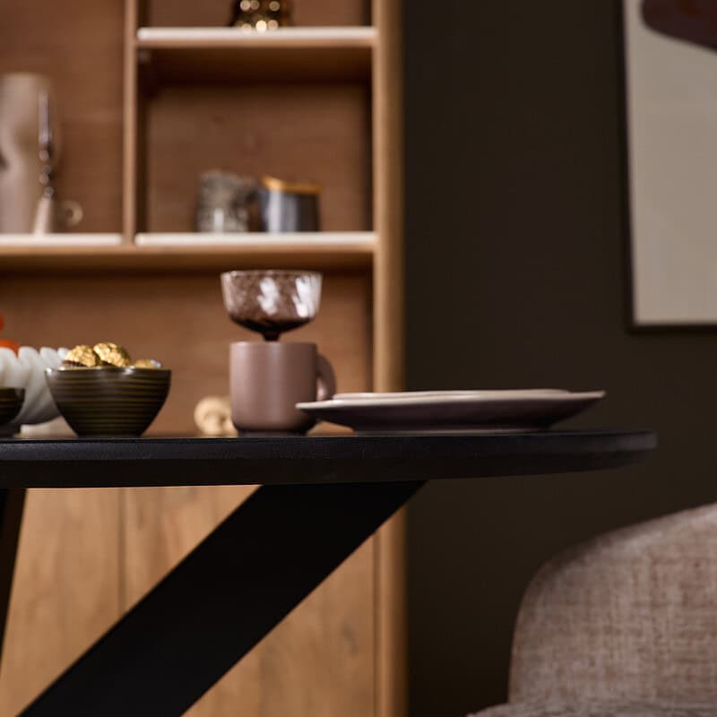 Eiken eettafel Ferris rond 110 cm in zwart, perfect voor moderne eetkamers, gecombineerd met stijlvolle accessoires en comfortabele stoelen.