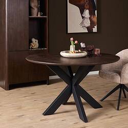 Eettafel Madison Brown met zwarte poot, 110 cm, in een modern interieur met houten vloer en decoratieve accessoires.