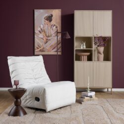 Zachte witte relaxfauteuil in een modern interieur met een diepe paarse muur, een stijlvolle boekenkast met decoratieve items en een kunstwerk van een vrouw in traditionele kleding, perfect voor een g.