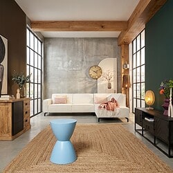 Moderne blauwe bijzettafel van mangohout in een stijlvolle woonkamer met industriële en natuurlijke elementen. Perfect voor het toevoegen van een kleurrijk accent en functionaliteit.