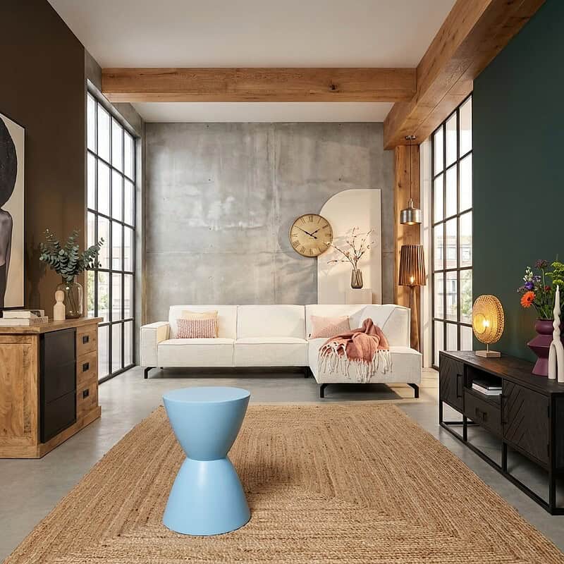 Moderne blauwe bijzettafel van mangohout in een stijlvolle woonkamer met industriële en natuurlijke elementen. Perfect voor het toevoegen van een kleurrijk accent en functionaliteit.