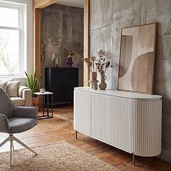 Interieur met vintage en moderne meubels, inclusief een witte buffetkast, planten, en abstract kunstwerk in een industrieel ingerichte woonkamer.