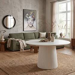 Gezellige woonkamer met groene bank, ronde witte tafel en natuurlijke decoraties, perfect voor een modern en comfortabel huis.