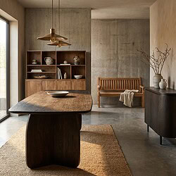 Een stijlvolle eetkamer met een grote houten eettafel, houten boekenkast en bank, gecombineerd met natuurlijke decoraties en een minimalistisch ontwerp.