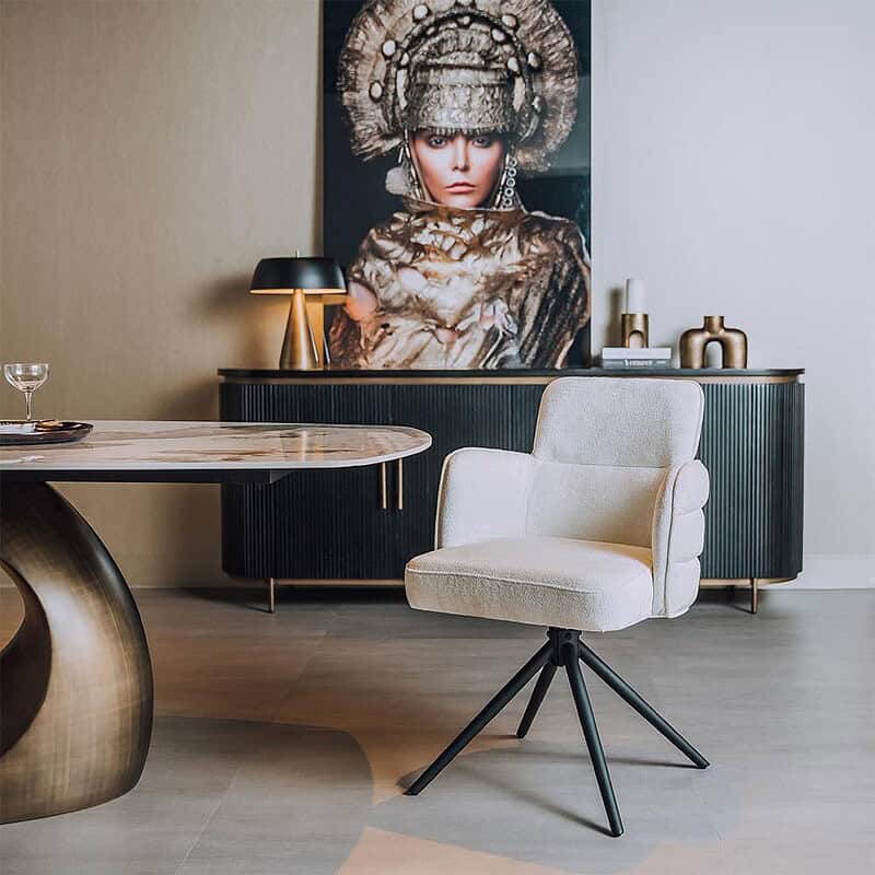 Moderne witte bureaustoel met zwarte poten en comfortabele armleuningen, geplaatst in een stijlvolle interieurruimte met een kunstwerk en decoratieve accessoires.