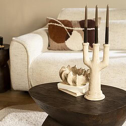 Moderner Couchtisch aus Holz mit Kerzen und einer dekorativen Schale in einem Wohnzimmer.