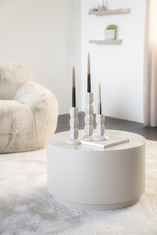 Moderner weißer runder Couchtisch in einem hellen Wohnzimmer, geschmückt mit drei Kerzen und einem Buch – perfekt für eine schlichte und stilvolle Einrichtung.