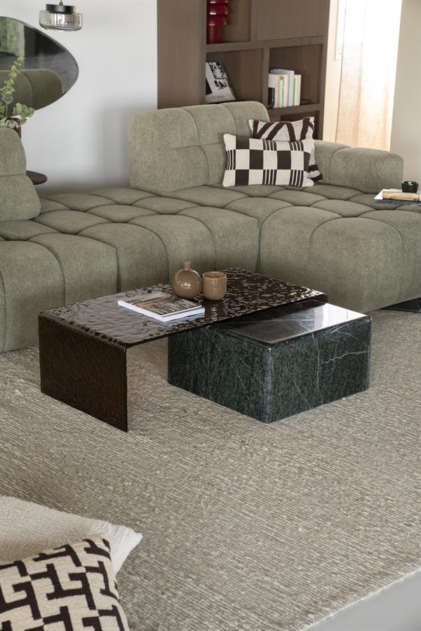 Ein modernes Wohnzimmer mit einem großen, bequemen grünen Sofa und stilvollen Couchtischen von Mokana Meubelen – perfekt für eine gemütliche und zeitgemäße Einrichtung.