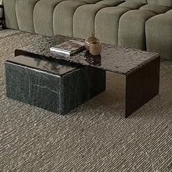 Ein modernes grünes Sofa mit gepolsterter Sitzfläche und einem schwarzen Couchtisch aus Holz im Wohnzimmer, dekorativ mit Kissen und Pflanzen für eine gemütliche Atmosphäre.