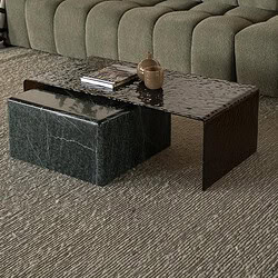 Ein modernes grünes Sofa mit gepolsterten Kissen und Zierkissen im Wohnzimmer, kombiniert mit einem Couchtisch aus schwarzem Marmor und einem Pflanzkübel.