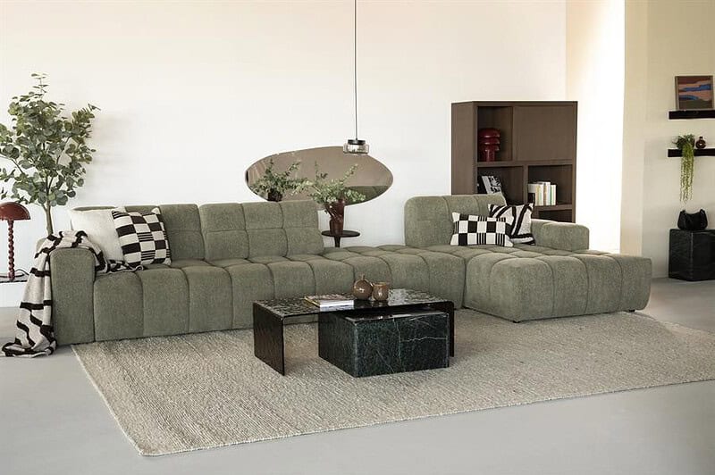 Modernes L-förmiges Sofa in einem hellen Wohnzimmer, perfekt für gemütliche Momente. Hergestellt von Mokana Meubelen, mit bequemen Kissen und einem stilvollen Look.