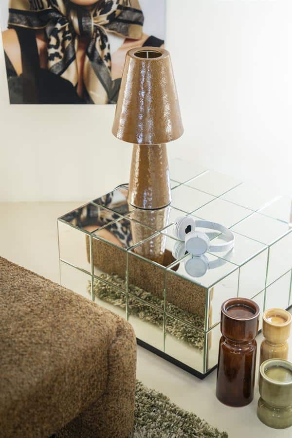 Goldene Tischlampe auf einem Spiegelschrank mit dekorativen Vasen und Kopfhörern – stilvolle Inneneinrichtung.