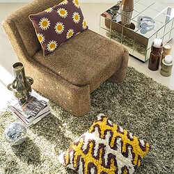 Gemütliches Wohnzimmer mit Vintage-Sofa, buntem Teppich und dekorativen Accessoires – perfekt für einen warmen und stilvollen Einrichtungsstil.