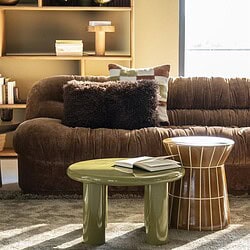 Gemütliches Wohnzimmer mit Möbeln von Mokana, darunter ein bequemes Sofa, Beistelltische und Deko-Accessoires für eine warme Atmosphäre.