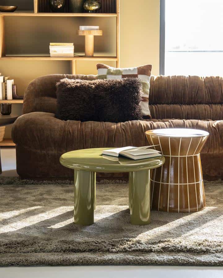 Gemütliches Wohnzimmer mit Möbeln von Mokana, darunter ein bequemes Sofa, Beistelltische und Deko-Accessoires für eine warme Atmosphäre.