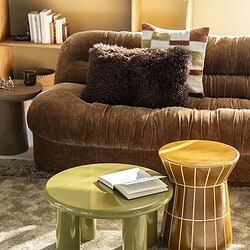 Gemütliches Wohnzimmer mit einem großen, weichen Sofa, Beistelltischen und einem Bücherregal – perfekt zum Entspannen und für einen stilvollen Einrichtungsstil.