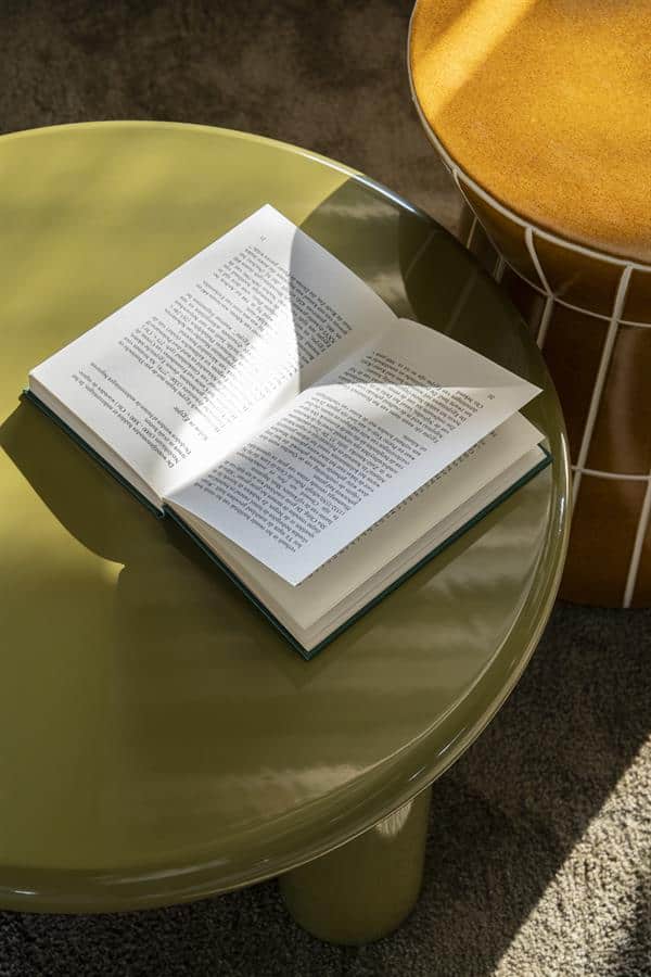 Moderner grüner Beistelltisch mit einem aufgeschlagenen Buch darauf, in einer stilvollen Einrichtung. Perfekt als Wohnaccessoire und für den praktischen Gebrauch.