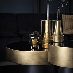 Elegante goldene Kerzenständer und Kerzen auf einer schwarzen Tischplatte in einem stilvollen Wohnzimmer. Perfekt für eine luxuriöse und moderne Atmosphäre.