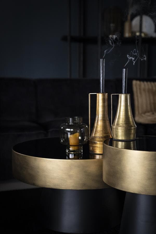 Elegante goldene Kerzenständer und Kerzen auf einer schwarzen Tischplatte in einem stilvollen Wohnzimmer. Perfekt für eine luxuriöse und moderne Atmosphäre.