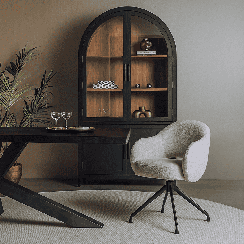 Een elegant interieur met een zwart houten kast en een comfortabele, lichtgrijze bureaustoel in een moderne woonruimte.