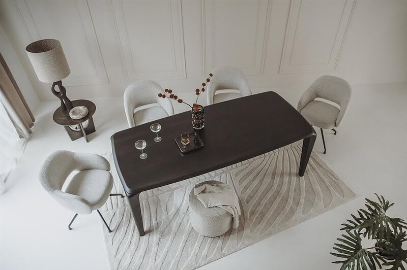 Moderne eettafel met witte stoelen, stijlvolle decoraties en een minimalistisch interieur voor een elegante eetruimte.