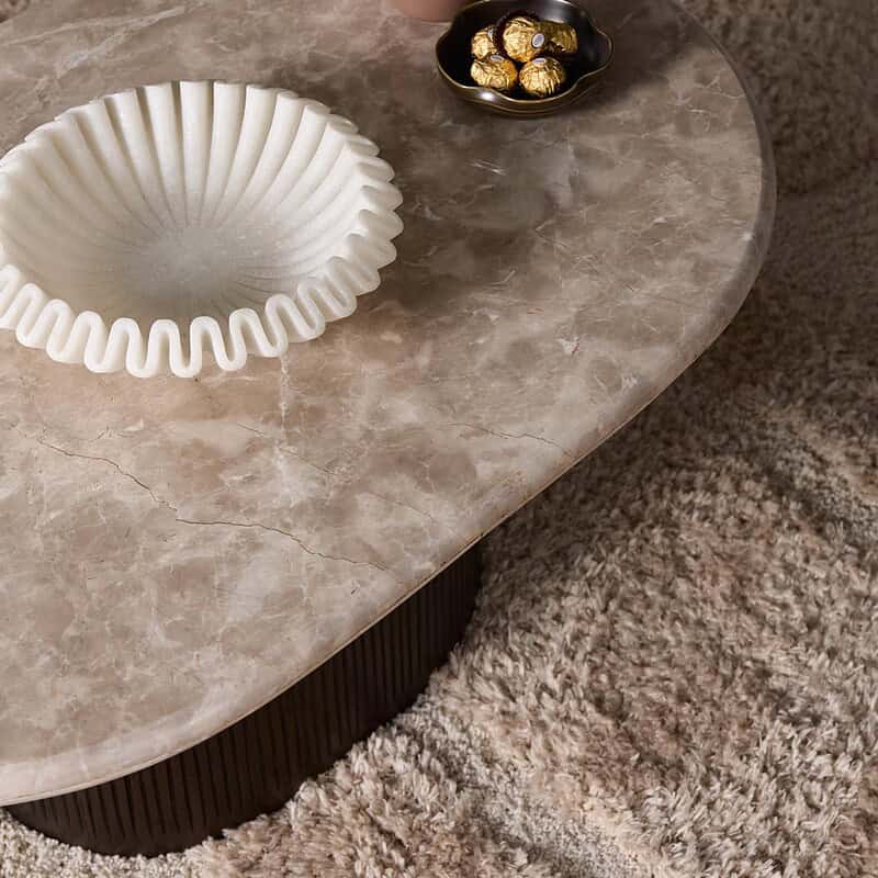 Moderne salontafel Noel van Mokana met een ronde marmeren bovenkant en een zwart onderstel, perfect voor een stijlvolle woonkamer.