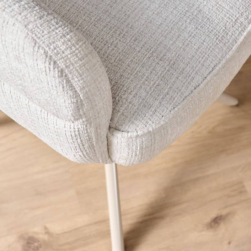Comfortabele eetkamerstoel Bella in off-white stof met zandkleurige poot en armleuningen, perfect voor een stijlvolle en gezellige eethoek.