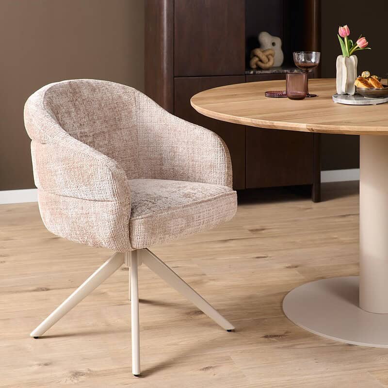 Comfortabele draaibare eetkamerstoel Bella in beige stof met zandkleurige poten, perfect voor een moderne eetkamer.