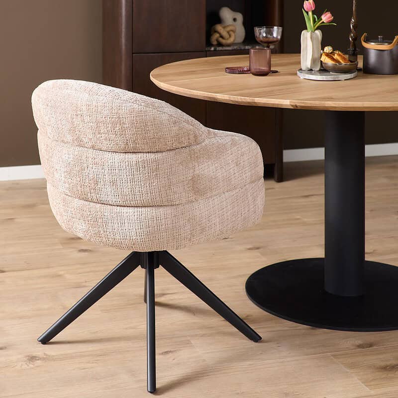 Comfortabele draaibare eetkamerstoel Bella in beige stof met zwarte poot, perfect voor moderne eetkamers en interieurdesign.
