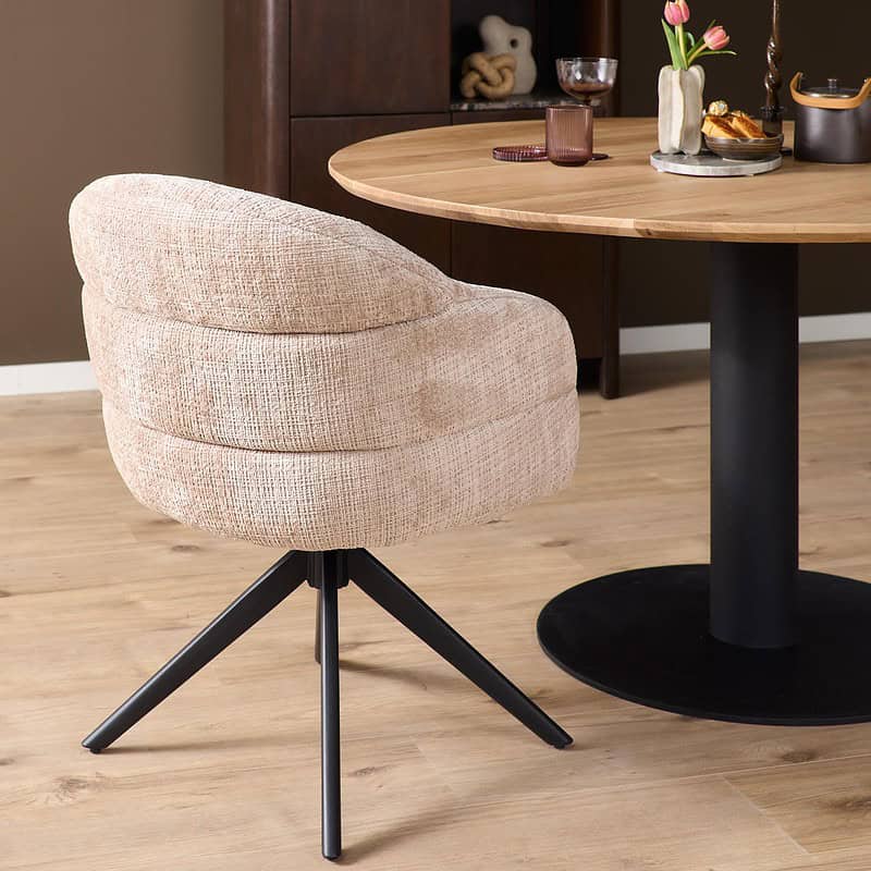 Comfortabele beige eetkamerstoel Bella met zwarte poot en armleuningen, perfect voor een stijlvolle en gezellige eethoek.