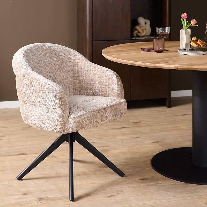 Comfortabele beige eetkamerstoel Bella met zwarte poot en armleuningen, perfect voor een stijlvolle en gezellige eethoek.