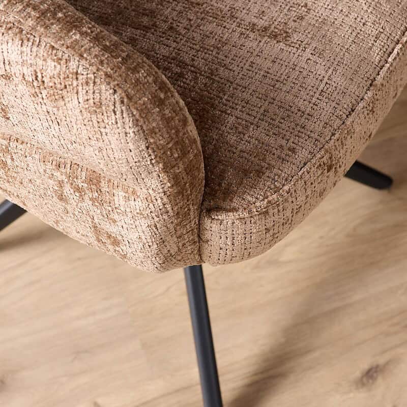 Comfortabele eetkamerstoel Bella in cinnamon stof met zwarte poten en armleuningen, perfect voor een stijlvolle en gezellige eethoek.