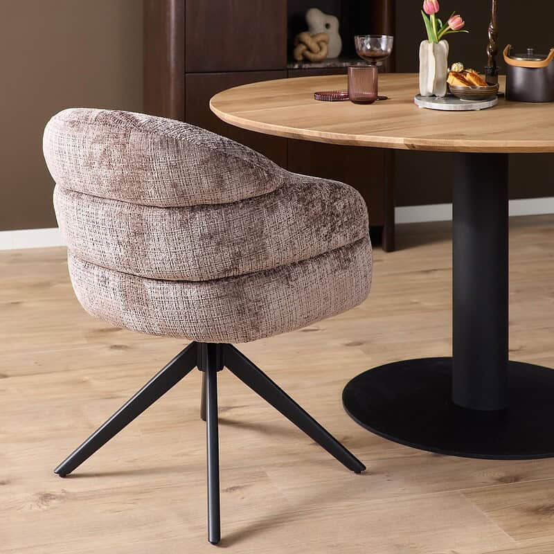 Comfortabele draaibare eetkamerstoel Bella Clay met zachte bekleding en zwart onderstel, perfect voor moderne eetkamers en gezellige eetervaringen.