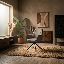 Een stijlvolle woonkamer ingericht met een comfortabele fauteuil, grote groene planten en natuurlijke decoratie. Perfect voor een warme, gezellige sfeer met hoogwaardige meubels van Mokana.