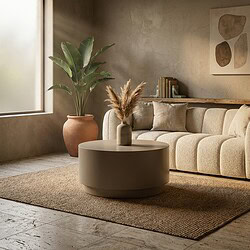 Gemütliches Wohnzimmer mit einem beigen Sofa, einer großen grünen Pflanze in einem Terrakottatopf und einem runden Couchtisch mit dekorativen Vasen – alles in einer hellen, natürlichen Atmosphäre.