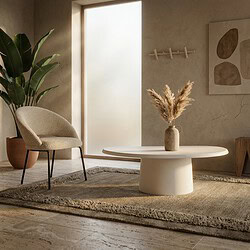 Gemütliches Wohnzimmer mit modernen Möbeln, einem runden weißen Couchtisch mit Vase und Trockenblumen, einem bequemen Sessel und einer großen grünen Pflanze, natürliches Licht.