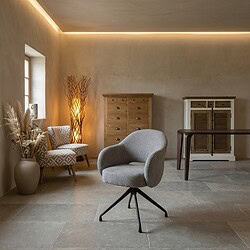 Moderne woonkamer met houten en stoffen meubels, inclusief een comfortabele draaistoel, een houten ladekast en een decoratieve vaas met droogbloemen, in een rustige, natuurlijke sfeer.