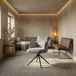 Moderne woonkamer met Mokana meubels, inclusief een comfortabele grijze fauteuil, een groene bank en een houten bank, in een minimalistische en sfeervolle setting.