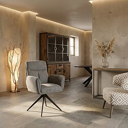 Een stijlvolle houten kast gecombineerd met een comfortabele, lichtgrijze fauteuil in een minimalistisch interieur. Perfect voor een gezellige en functionele woonruimte.