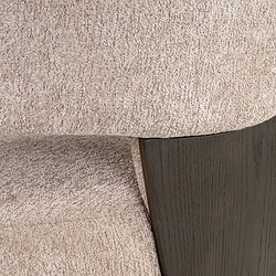 Close-up van een moderne fauteuil met beige bekleding en zwarte houten pootjes, perfect voor een stijlvolle woonkamer of kantoorinterieur.