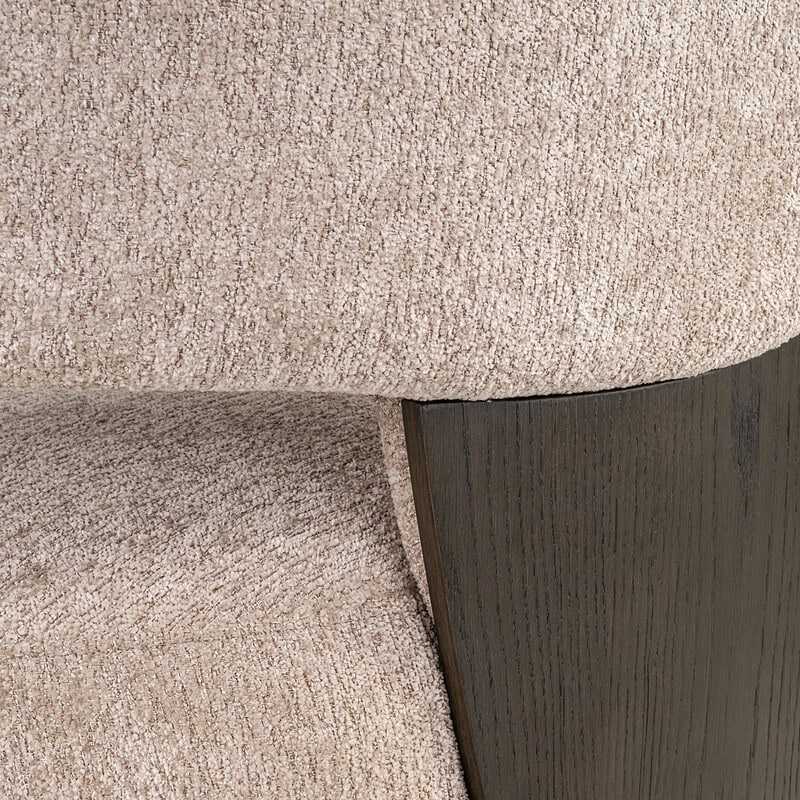 Close-up van een moderne fauteuil met beige bekleding en zwarte houten pootjes, perfect voor een stijlvolle woonkamer of kantoorinterieur.
