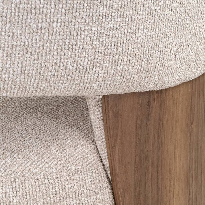 Detail van een bank met een houten poot en beige stoffen bekleding, perfect voor een moderne woonkamer.