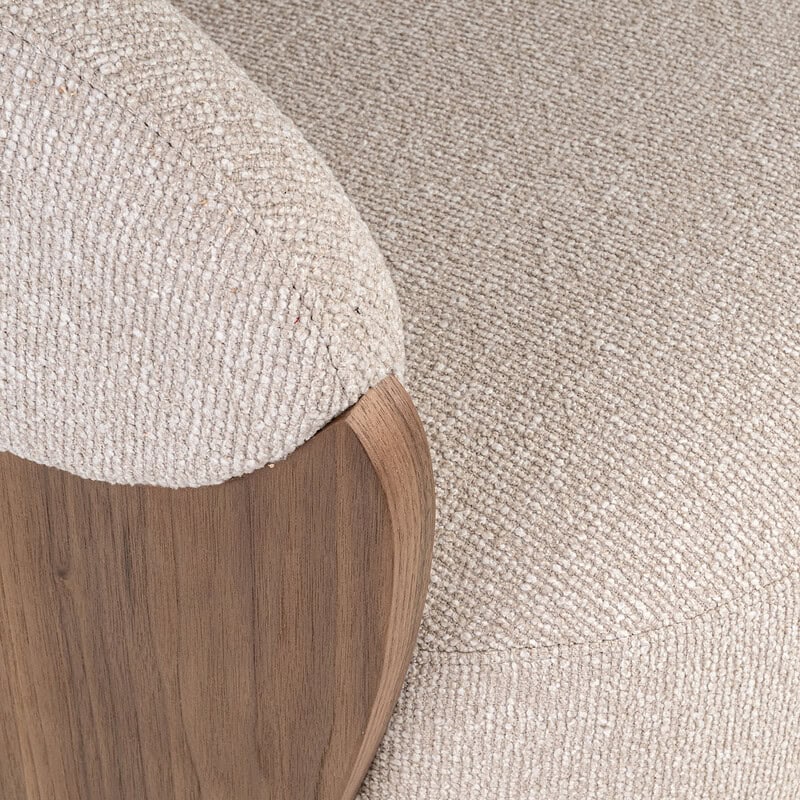 Comfortabele fauteuil met houten armleuningen en zachte stoffen bekleding, perfect voor een gezellige zithoek.