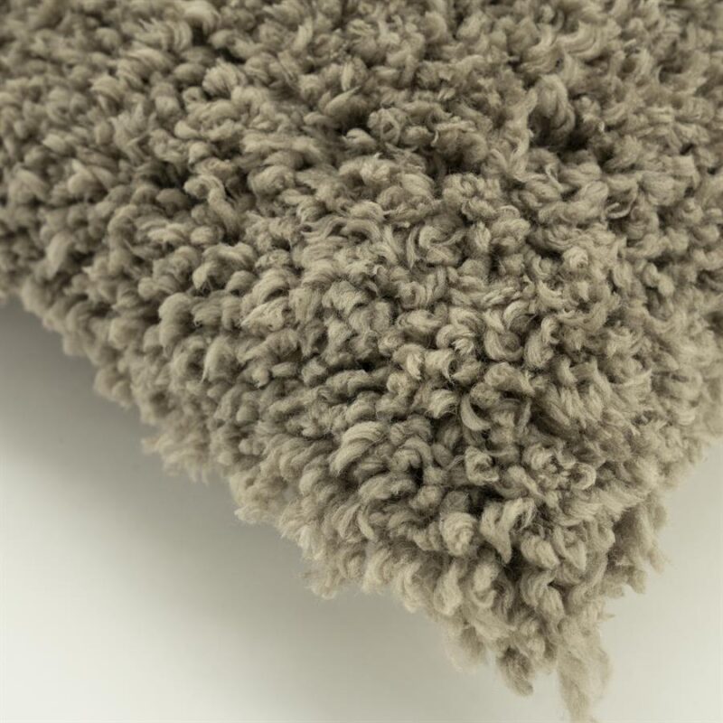 Dichtbij opname van een zacht, wollig tapijt met een knuffelbare textuur, perfect voor een gezellige woonkamer.